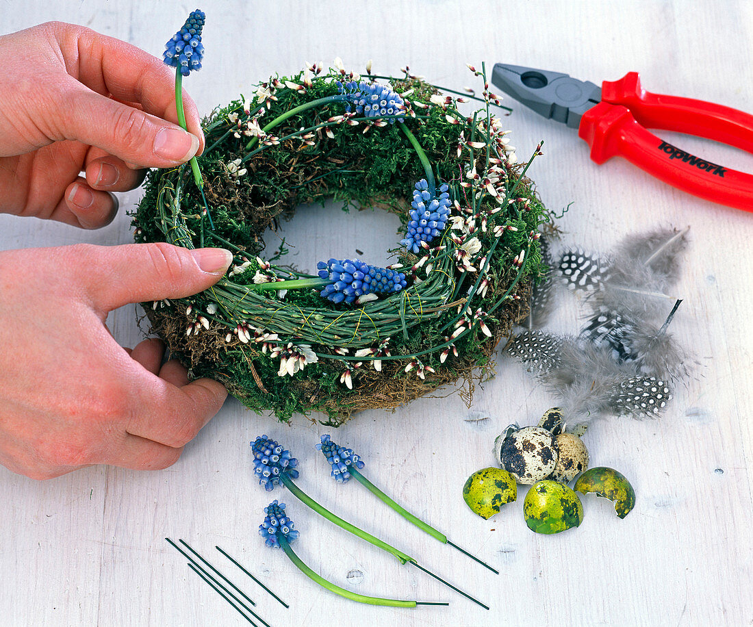 Easter wreath with grape hyacinths, feathers and eggs