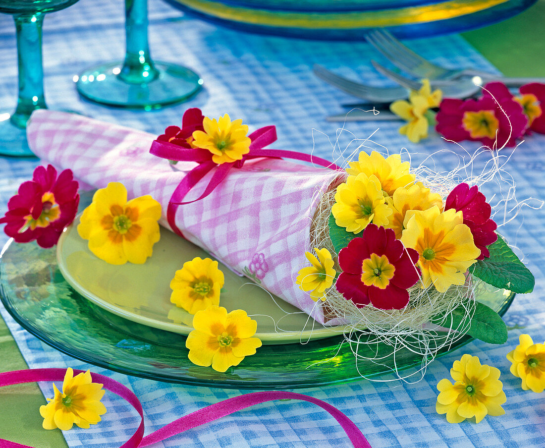 Primula as posy in rolled napkin