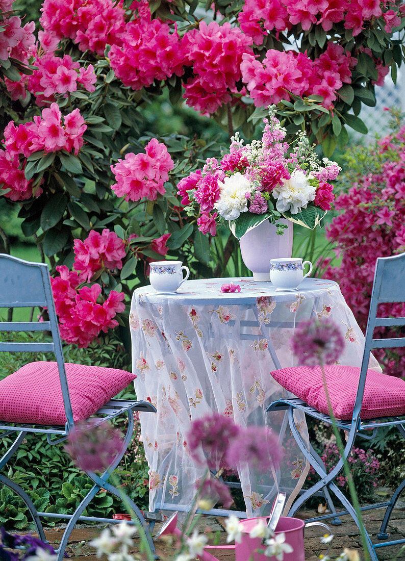 Light blue metal set in front of flowering rhododendron