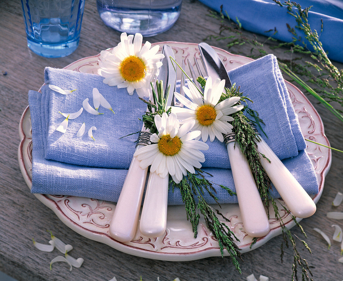 Leucanthemum flowers and grasses on blue cloth napkins