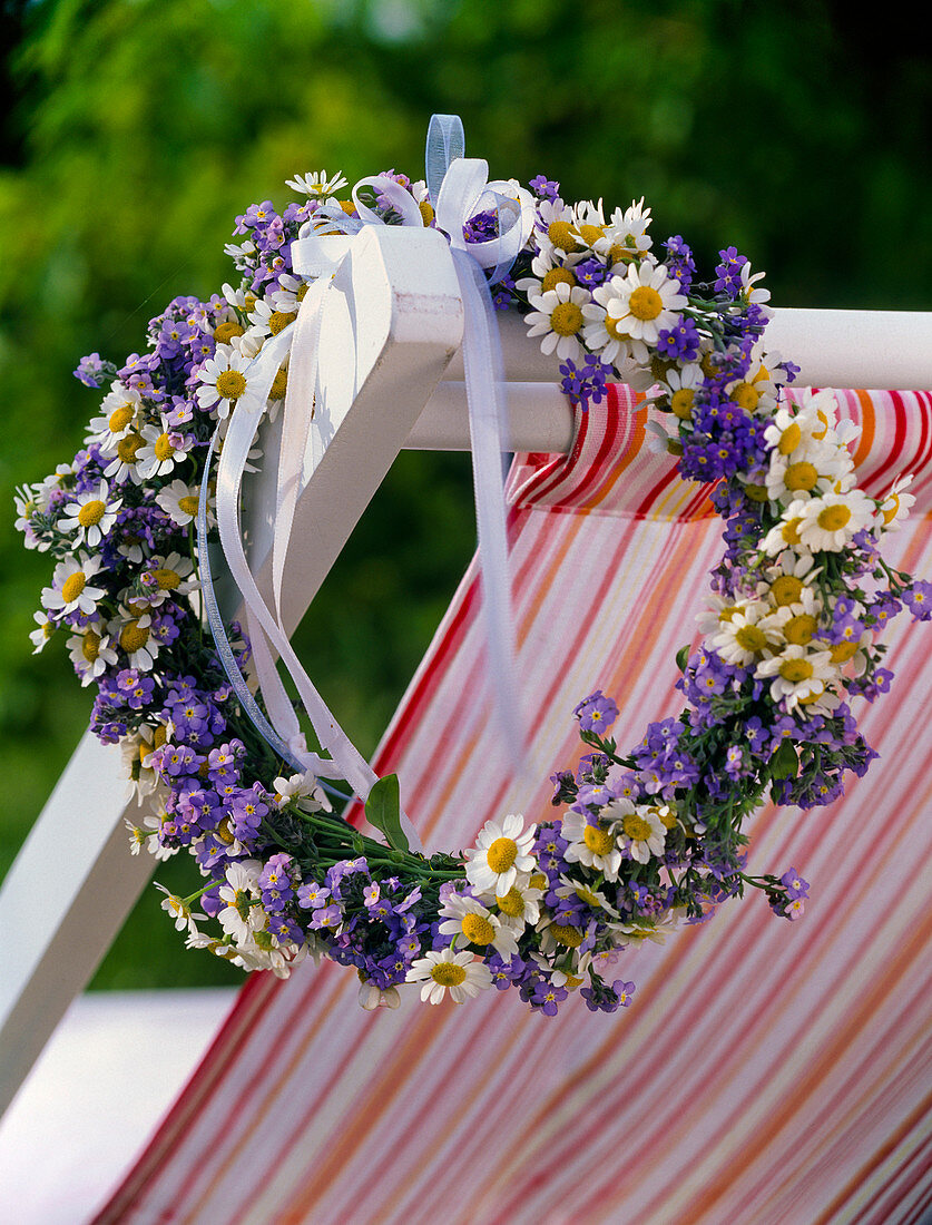 Wreath of Chamomilla (camomile) and Myosotis (forget-me-not) on backrest