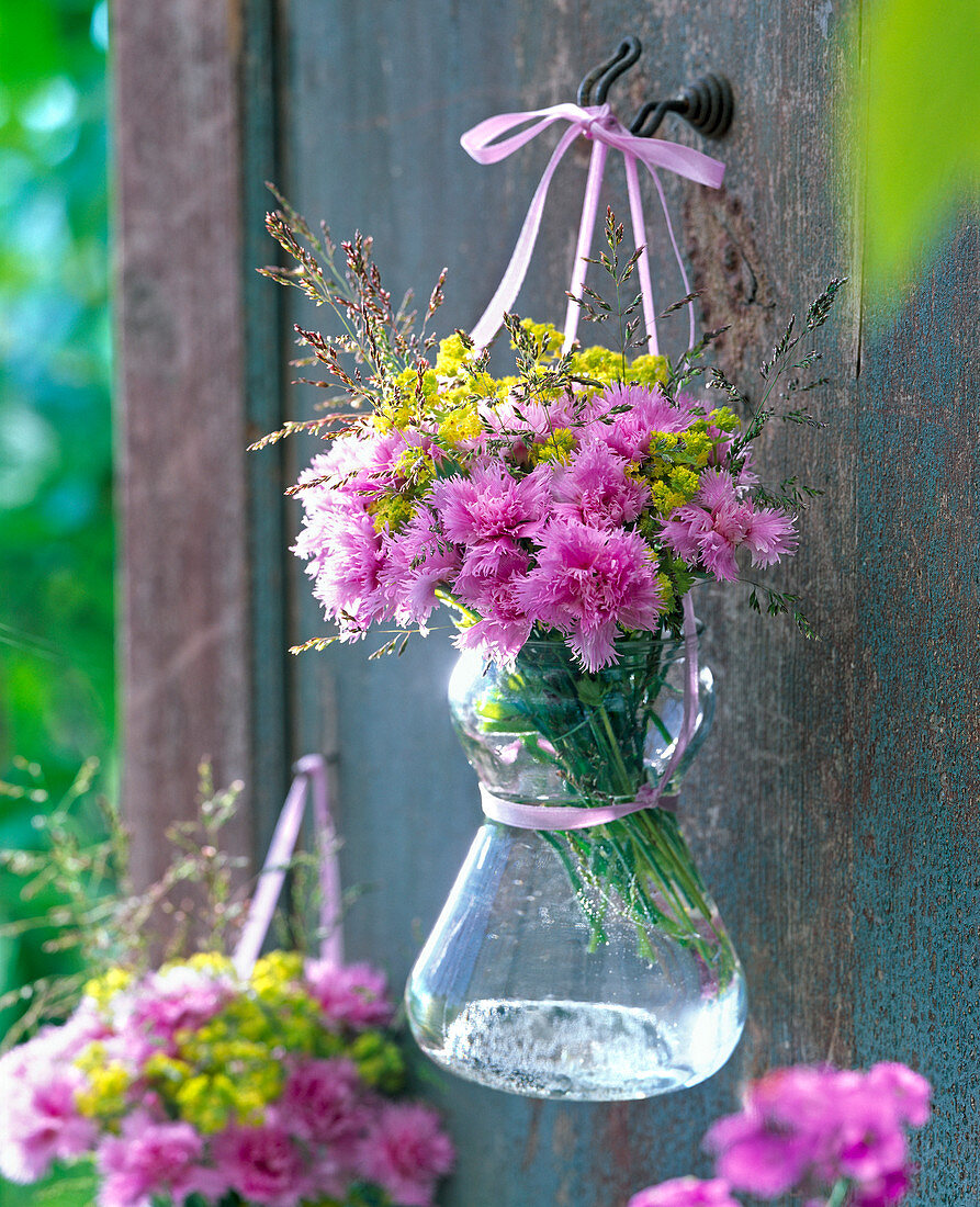 Dianthus (carnation), Alchemilla (lady's mantle), grasses in glass vase