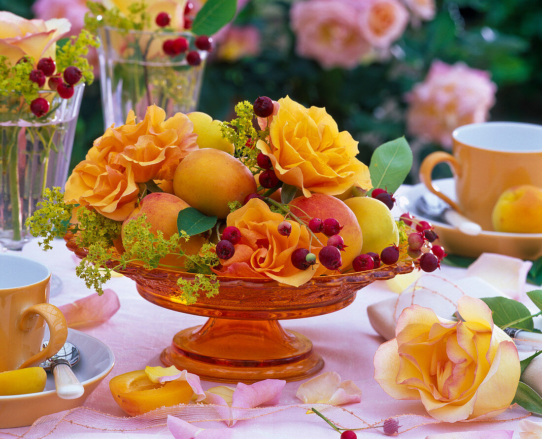 Pink (roses, orange), Alchemilla (lady's mantle) in orange glass bowl