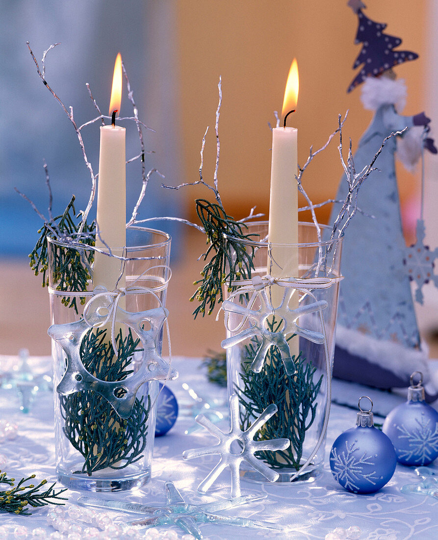 Juniperus (Juniper) in glasses with white candles, glass stars