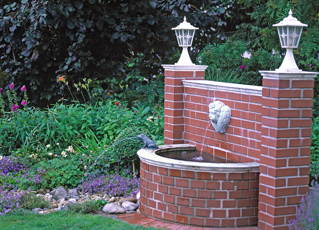 Gargoyle 'Angel's Head' with brick basin on brick wall