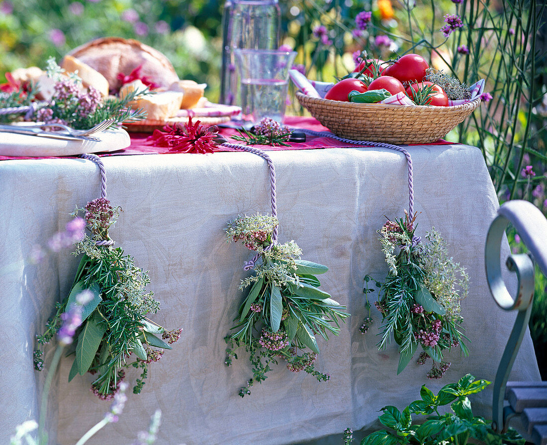 Herbs as table decoration with bouquets of salvia, rosmarinus