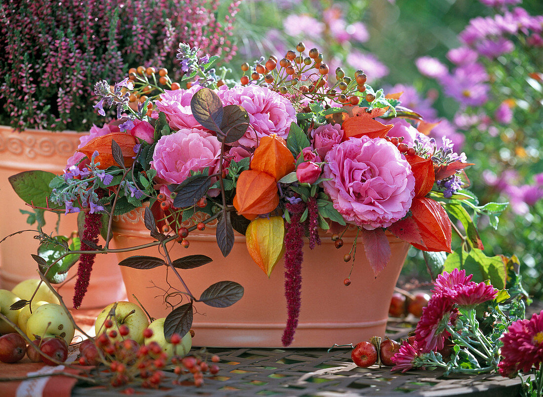 Autumn arrangement with pink (roses and rose hips) and physalis