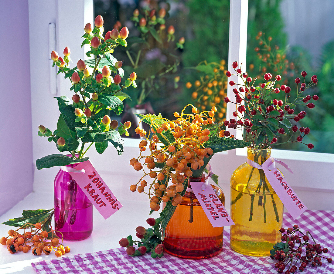 Sträuße aus Hypericum (Johanniskraut), Photinia (Glanzmispel), Rosa (Rosen)