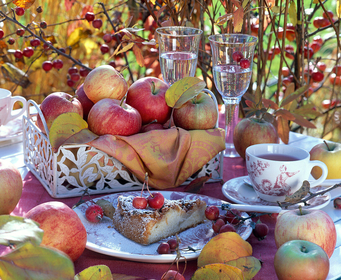 Malus (apples) in flat basket, apple pie, tea set, autumn leaves, glasses