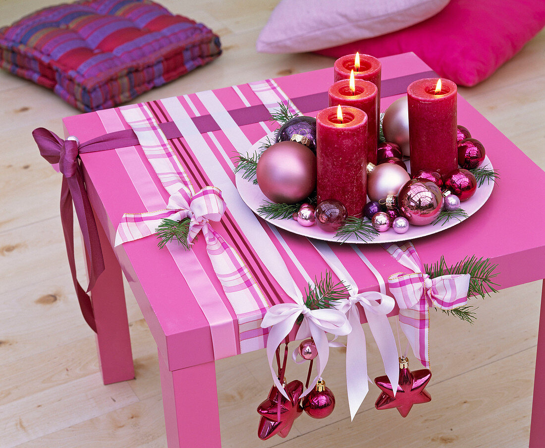 Rosa Tisch mit Bändern und Adventsschmuck