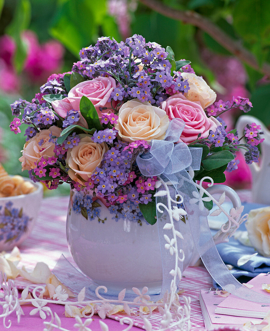 Strauß aus Rosa (Rosen) und Myosotis (Vergißmeinnicht) mit Schleife in Kanne