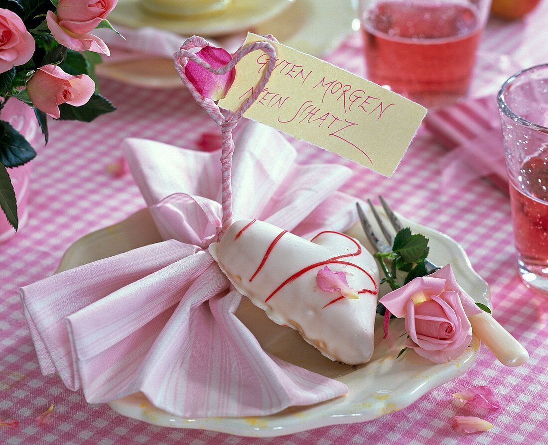 Rose, petit-four in heart shape, folded striped napkin