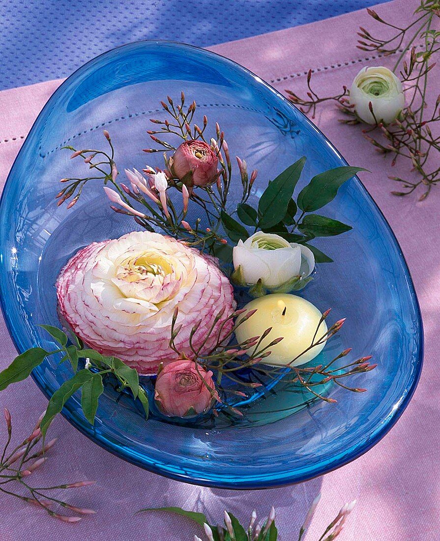 Ranunculus flowers and jasmine in water