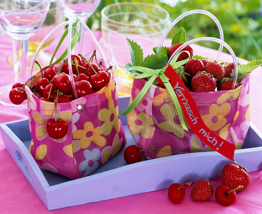 Kleine Taschen gefüllt mit Prunus (Kirschen) und Fragaria (Erdbeeren)