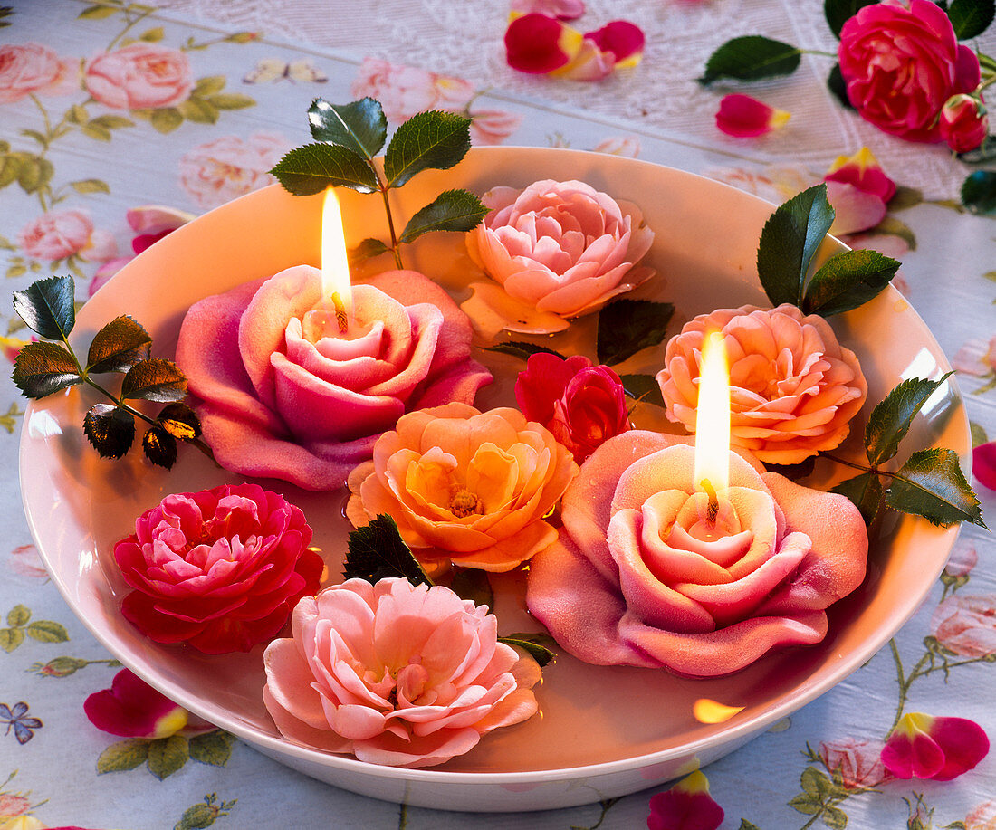 Blossoms of pink (roses), floating candles in the shape of roses in a bowl