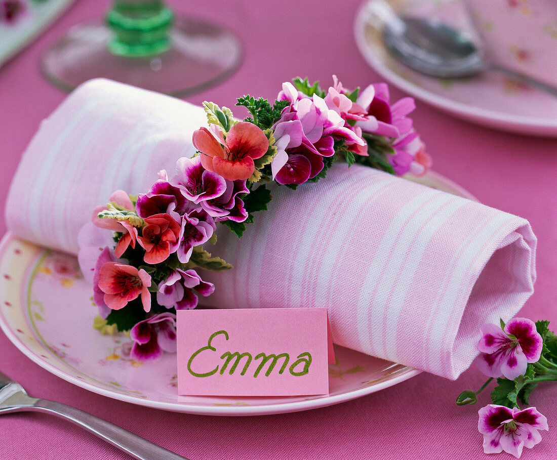 Pelargonium napkin ring around napkin, name tag 'Emma'