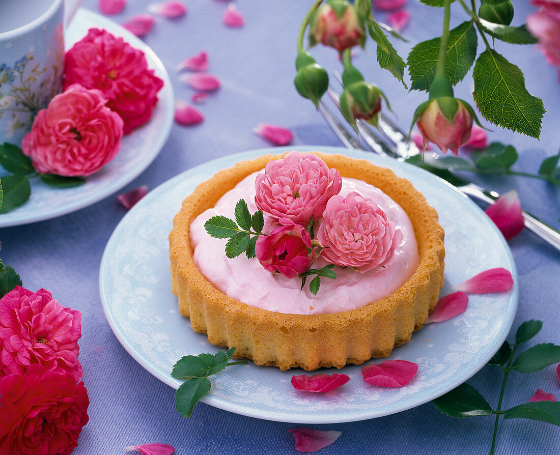 Kleine Torte mit Rosa (Rosen) dekoriert auf blauem