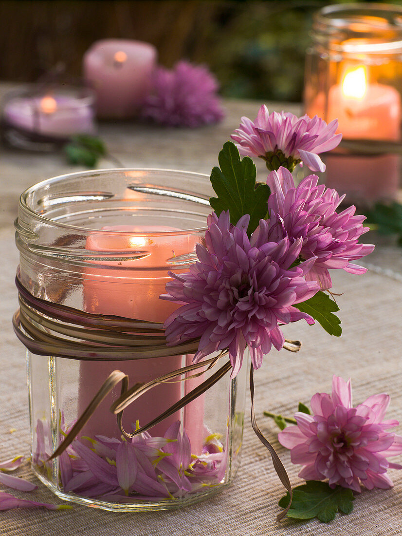 Windlicht mit Chrysanthemum (Herbstchrysanthemen) und trockenem Miscanthus