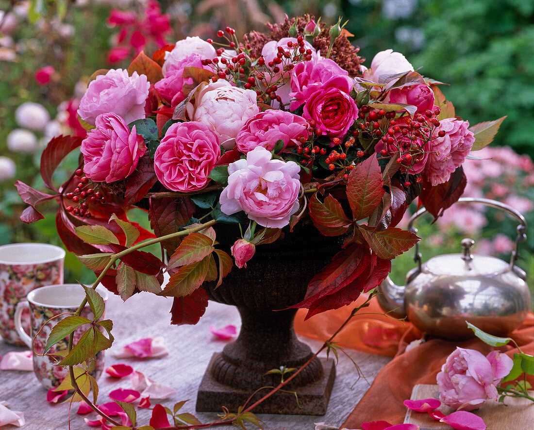 Bouquet of roses, rosehips, parthenocissus in bowl