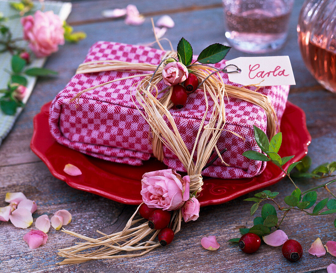 Book gift wrapped in cloth with pink (roses), rose hips