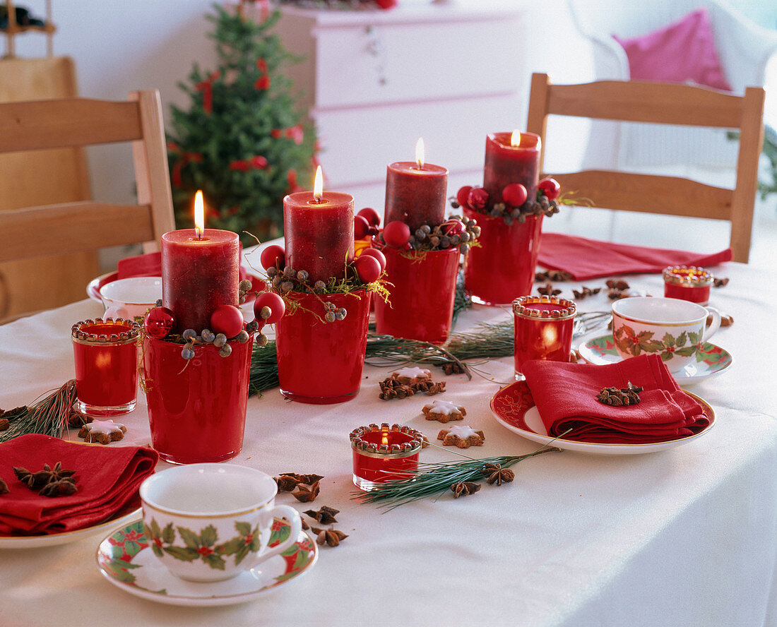 Christmas table decoration with red candles in glass pots