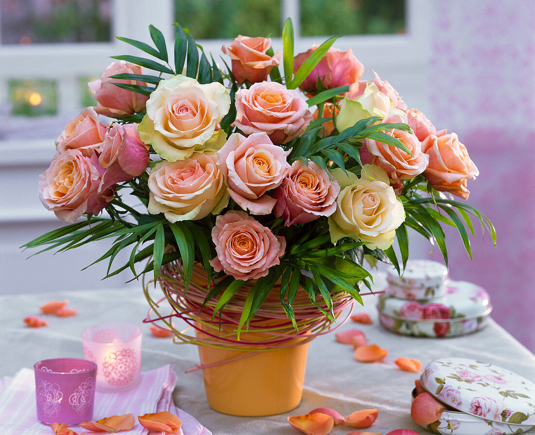 Bouquet of pink (roses) and Chamaedorea (mountain palm) in vase with peddigree cane