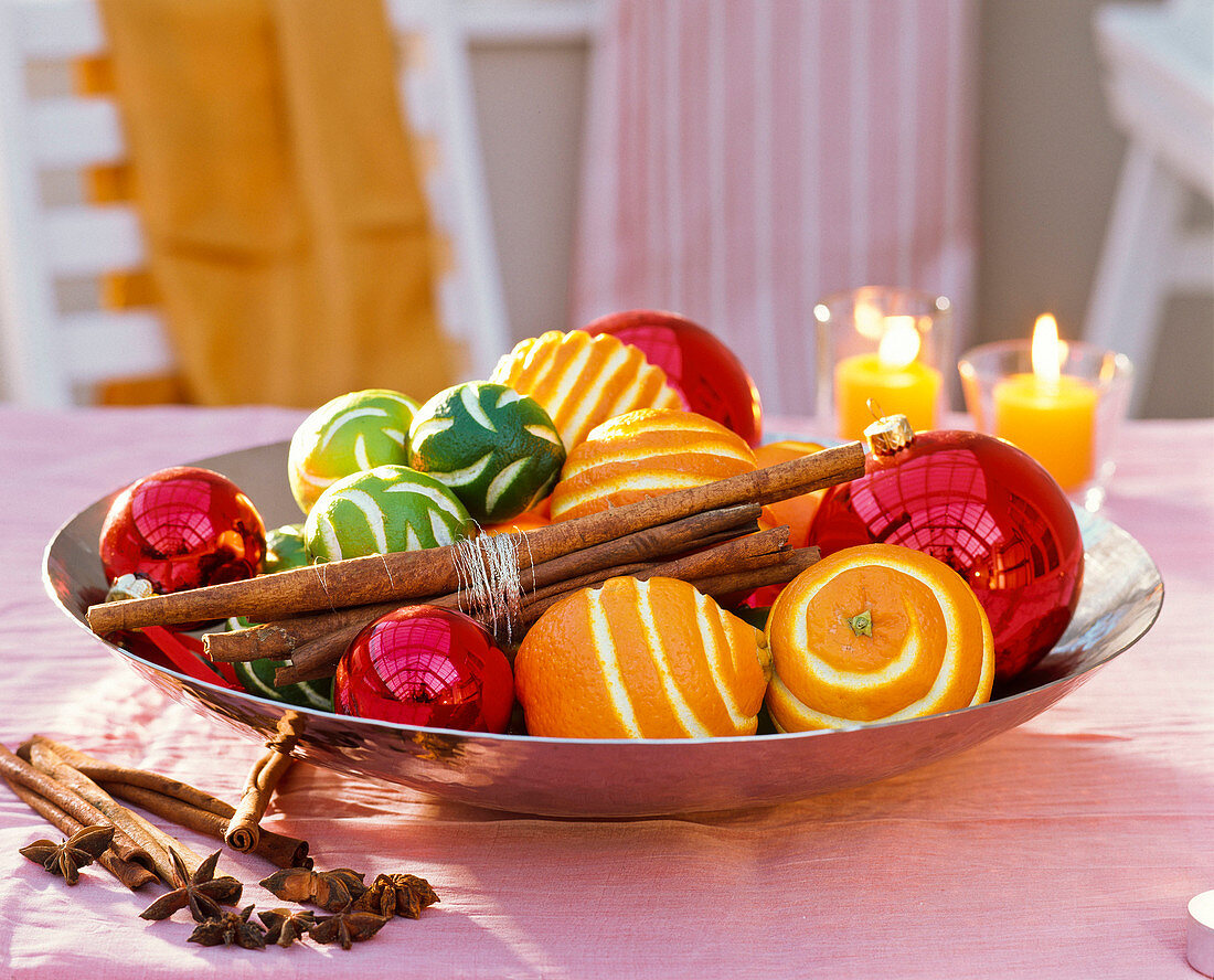 Citrus, cinnamon sticks, Christmas tree balls in bowl