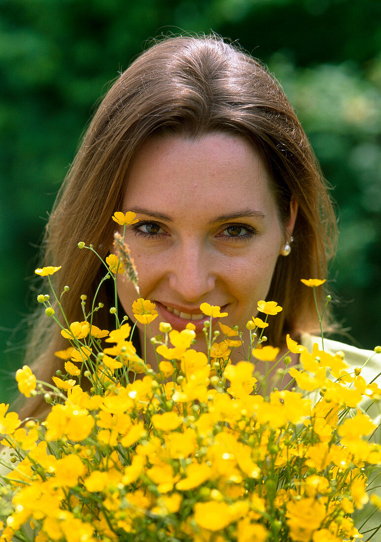 Woman with bouquet of Ranunculus acris (Buttercup)