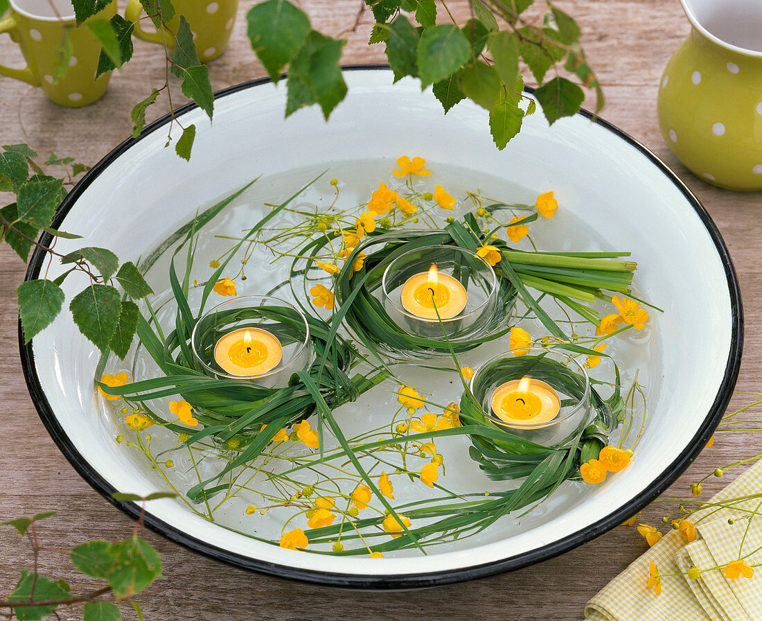 Grasses around tea lights, Ranunculus (buttercup) floating in a bowl