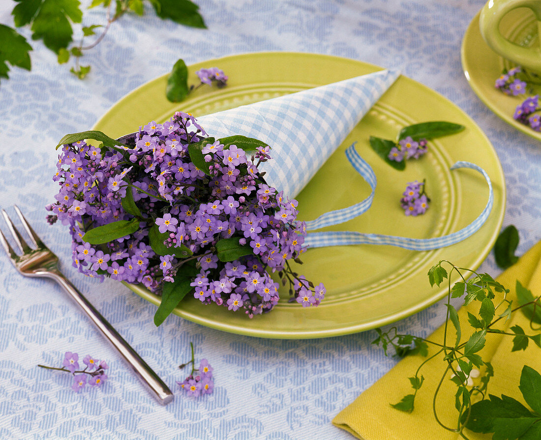 Myosotis (forget-me-not) in a bag-like rolled napkin