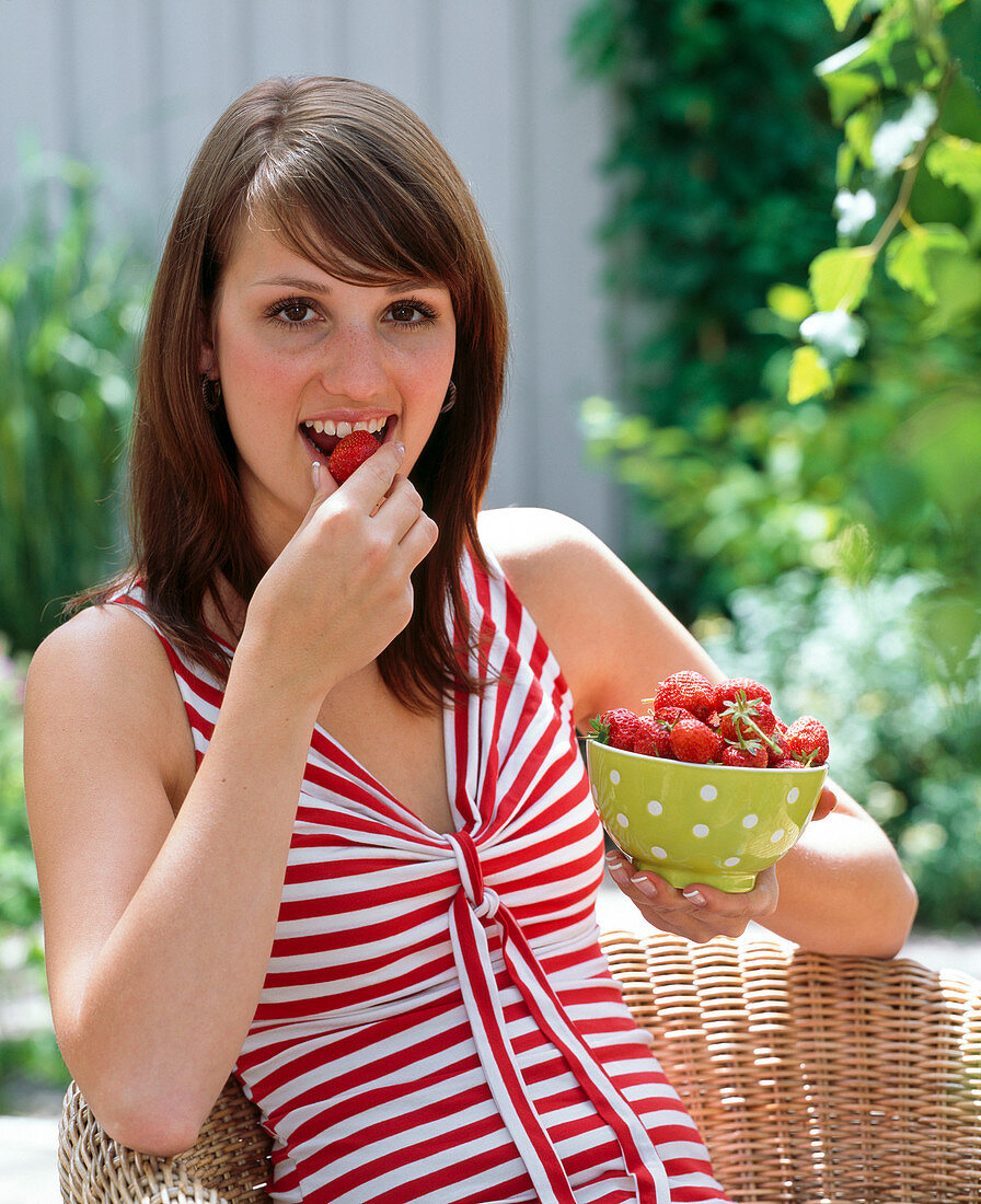Junge Frau frisst Fragaria (Erdbeeren)