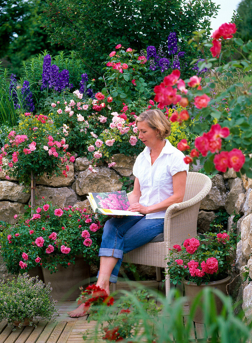 Terrace with roses, natural stone wall, wooden tiles