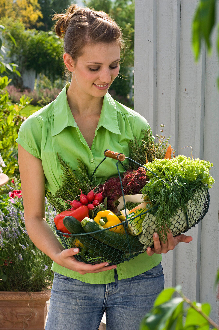 Woman with freshly bought organic vegetables in basket