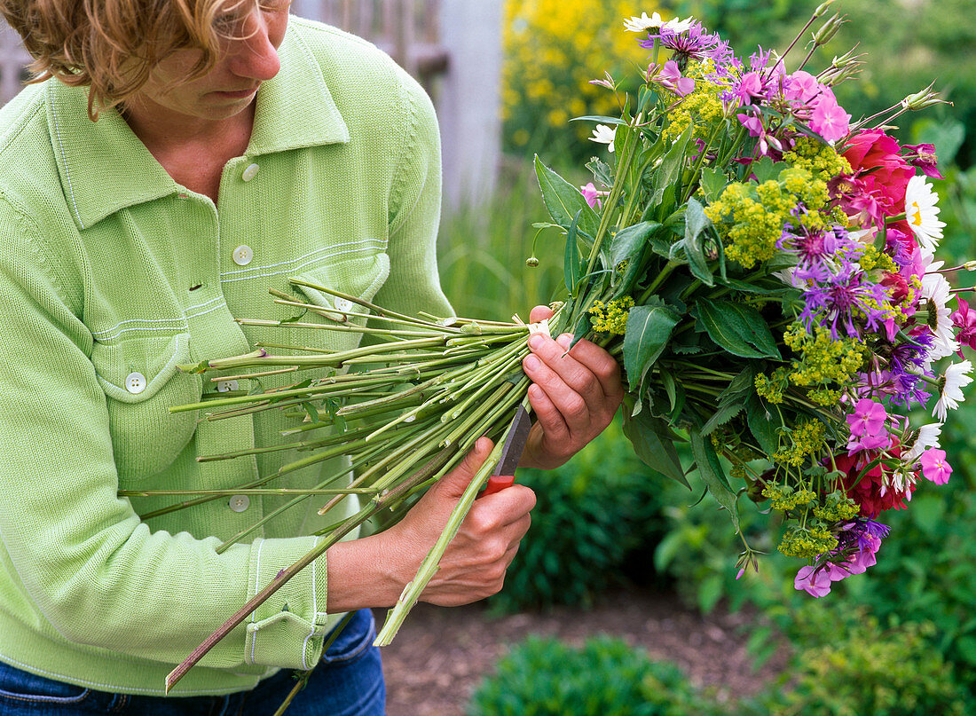 Tying colorful bouquet with peonies