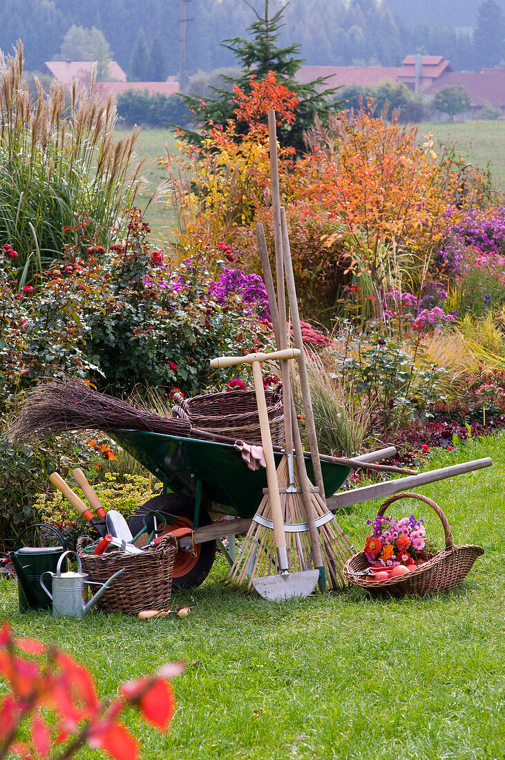 Working style with garden tools in front of autumn bed