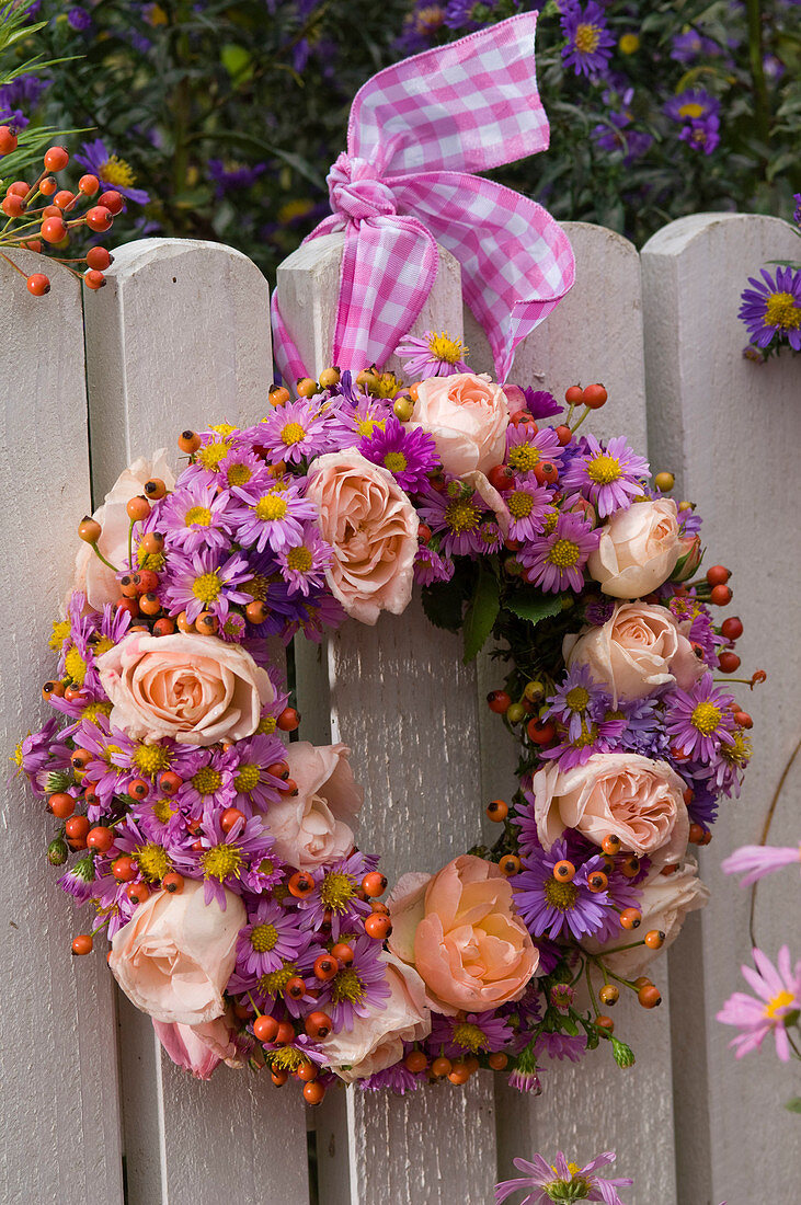 Kranz aus Rosa (Rosen und Hagebutten), Aster (Herbstastern) mit rosa -