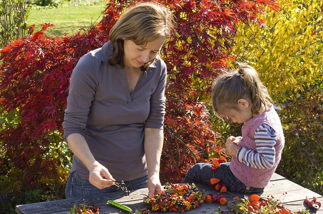 Mother and daughter making autumn decorations