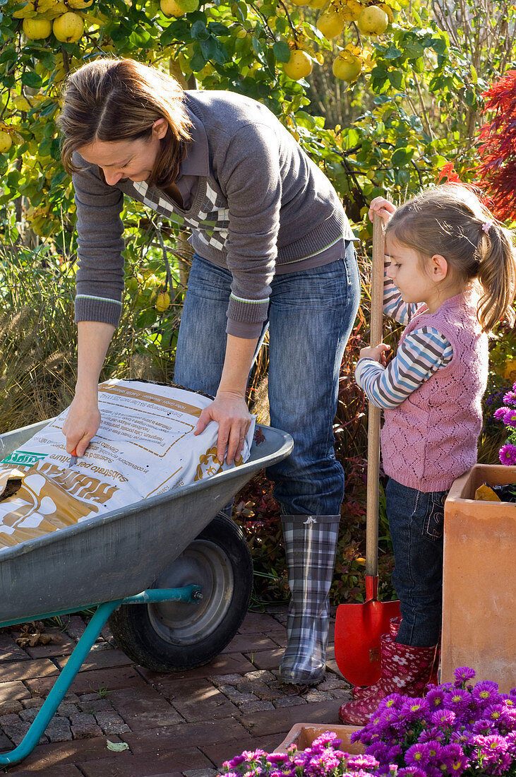 Mother and daughter planting terracotta pots (1/4)