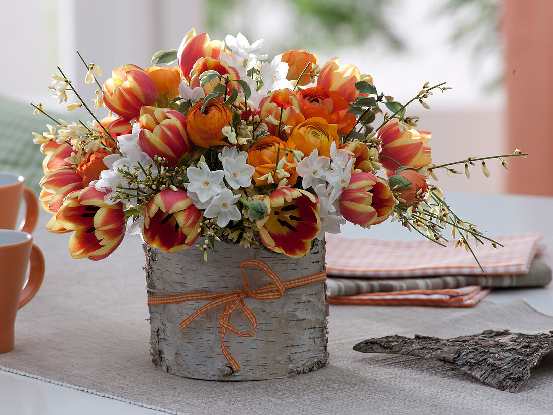 Orange-weißer Frühlingsstrauß aus Tulipa (Tulpen), Ranunculus (Ranunkeln)