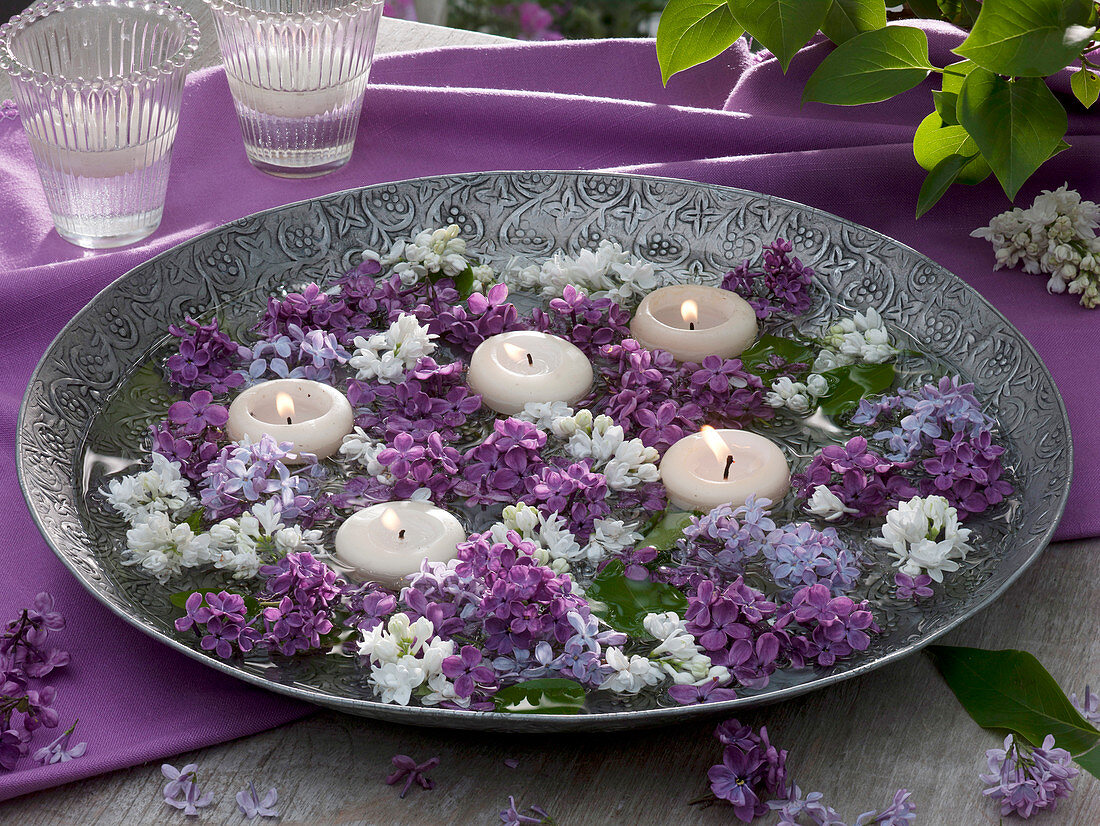 Large metal bowl with floating candles and syringa flowers