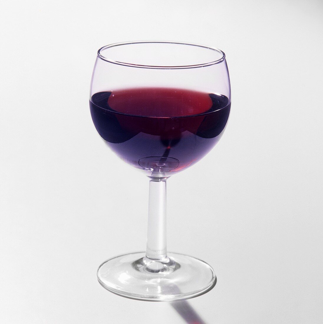 A glass of red wine against a light background