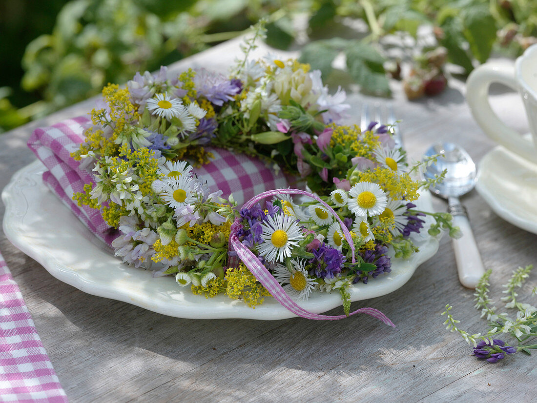 Small wreath of meadow flowers as napkin decoration