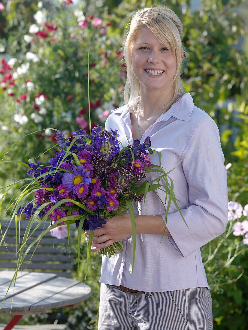 Young woman with bouquet of Callistephus (Summer Aster), Erigeron