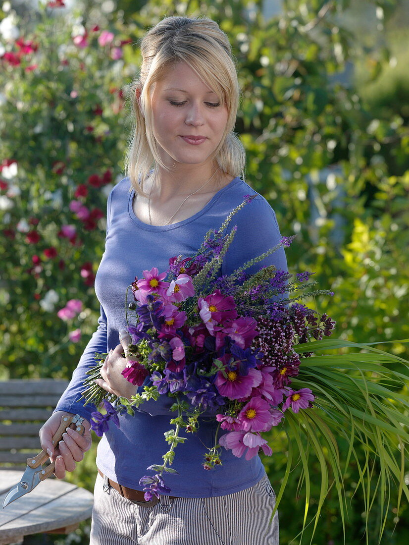 Young woman with freshly cut Cosmos (jewel basket)