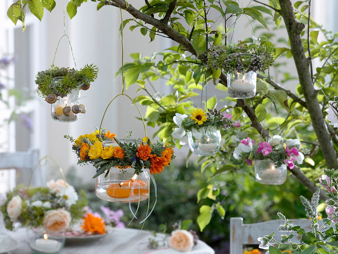 Windlichter aus Einmachgläsern mit Kränzchen aus Blüten und Kräutern