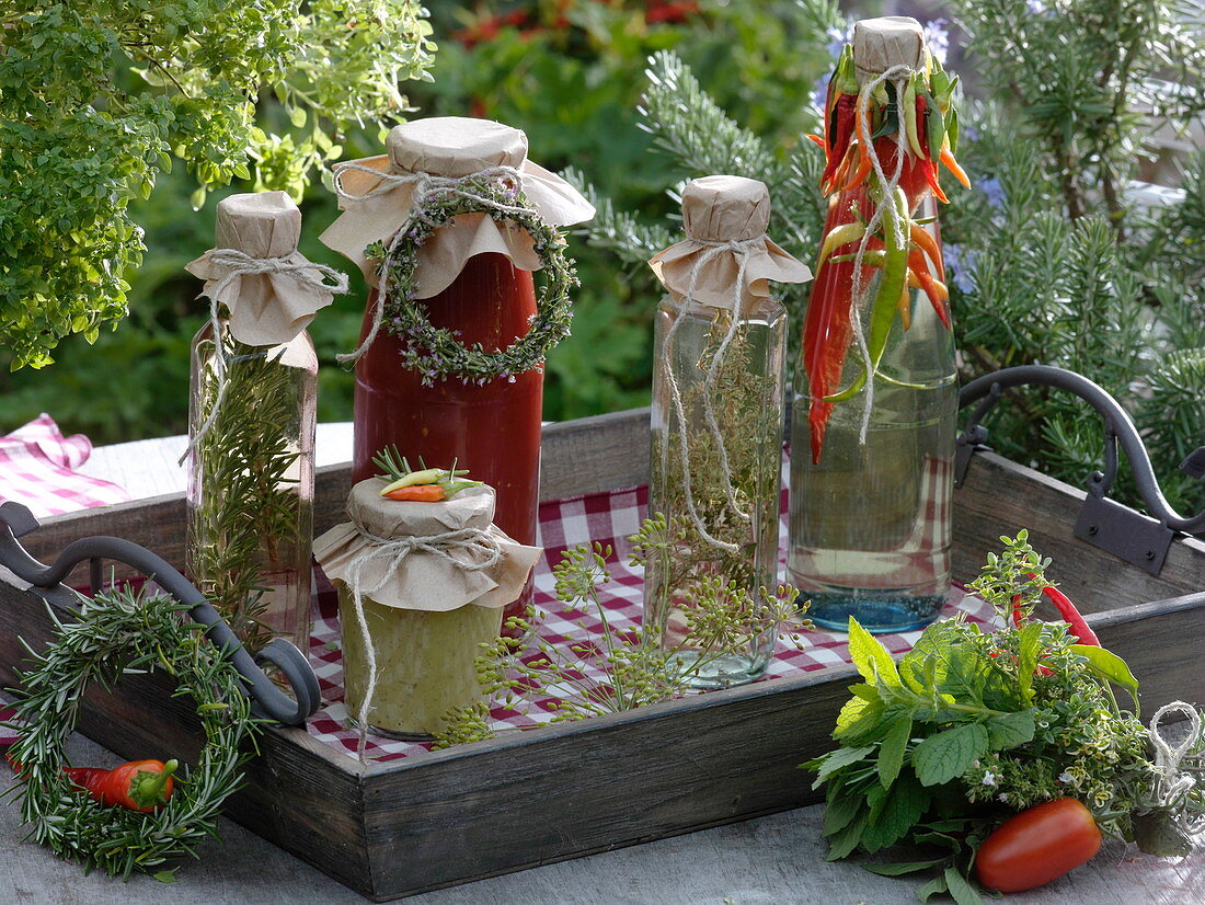 Bottles of herbs and peppers in oil, tomato-sugo and herb bouquets