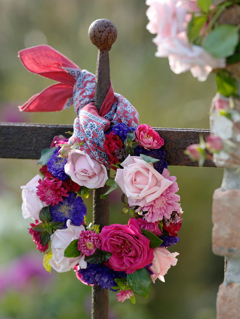 Roses and summer asters wreath on the fence