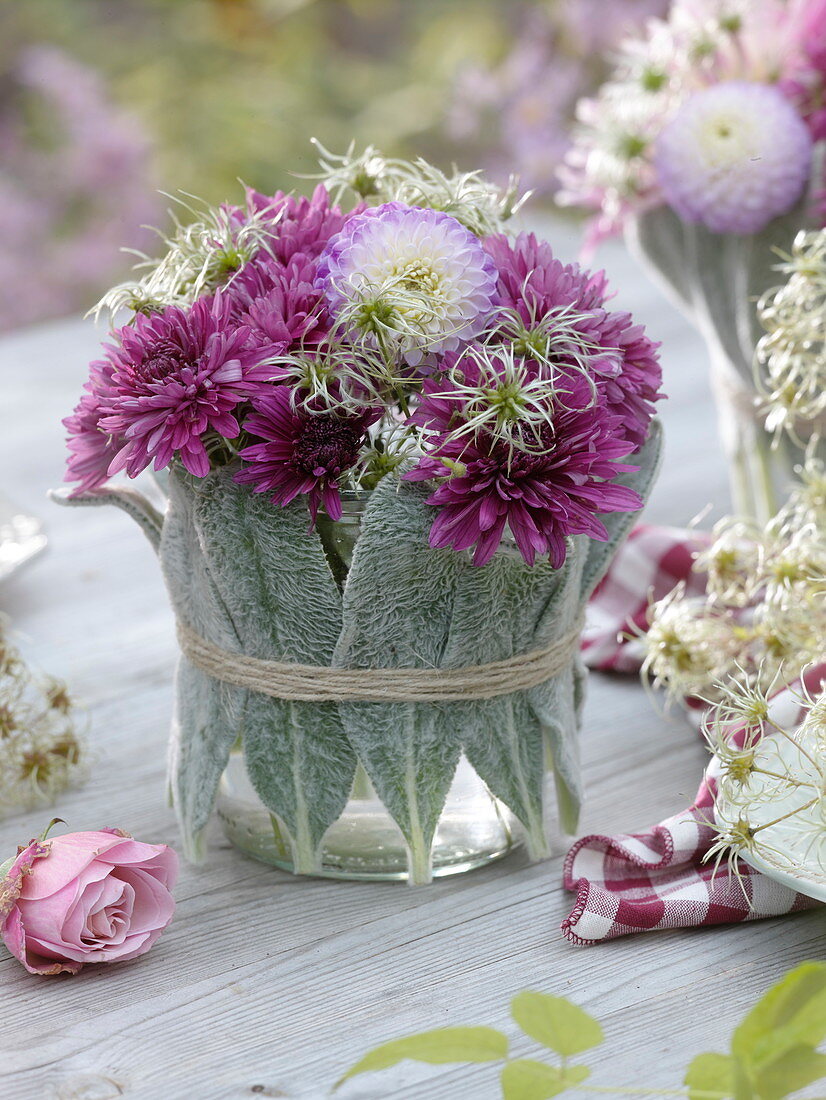 Glass vase with stachy leaves wrapped with autumn bouquet