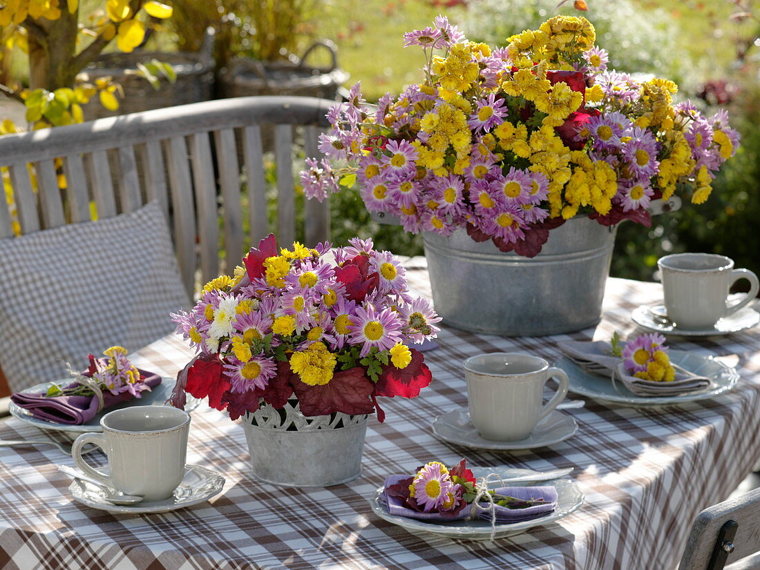 Autumn table decoration with autumn chrysanthemums and heuchera leaves