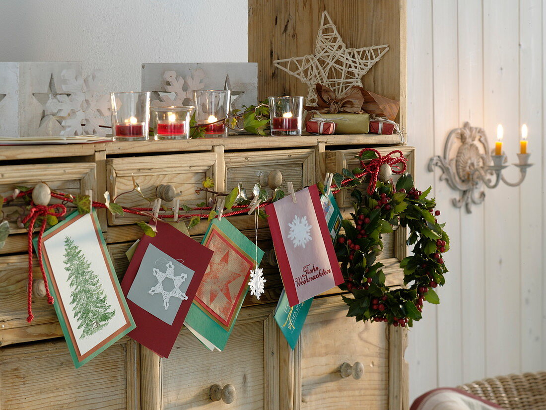 Cupboard decorated with a wreath of holly, Christmas cards